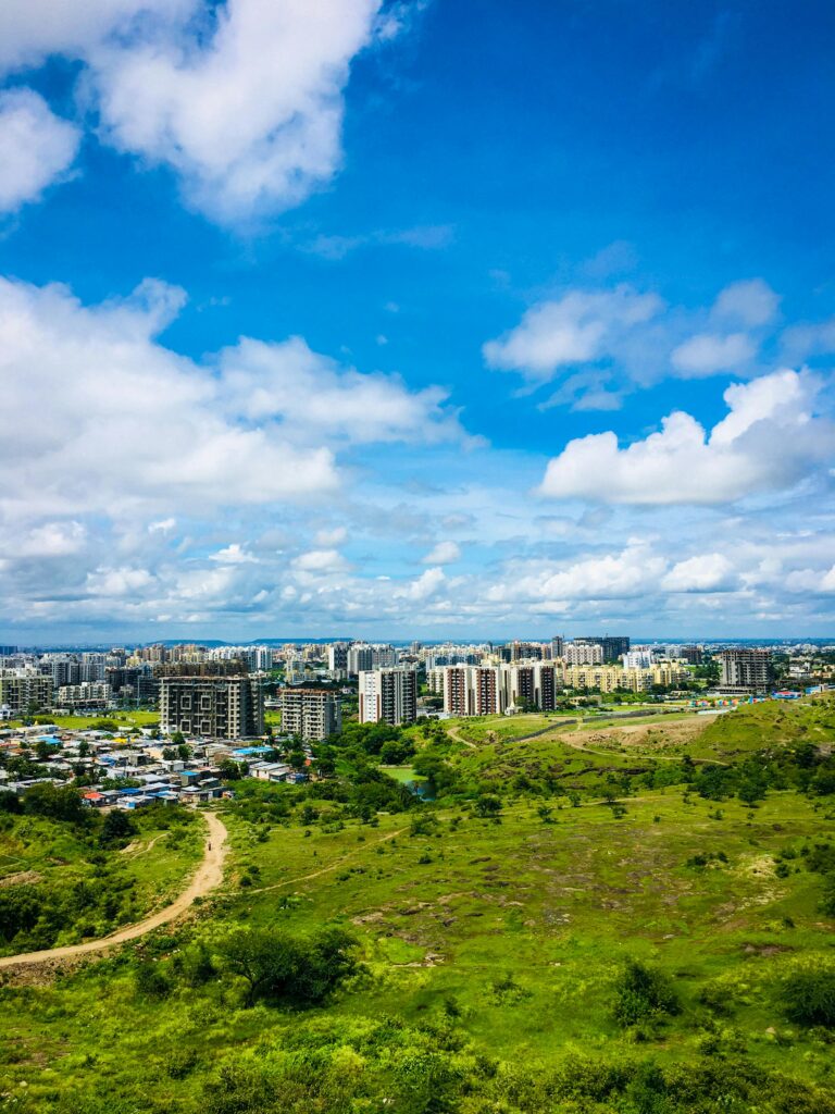 Stunning aerial view of Pune's cityscape with lush greenery and vibrant blue sky, showcasing urban development.